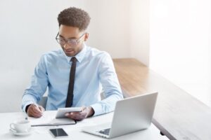 Man working at desk with laptop.