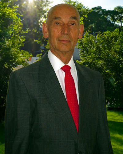 Man in suit with red tie outside.